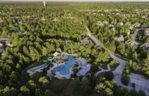 Alberca con toboganes y áreas de descanso en la comunidad Woodforest.