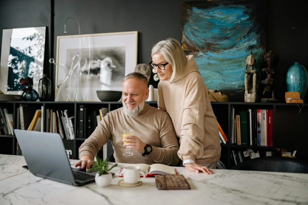 Pareja de inversionistas usando una computadora portátil para calcular el ROI inmobiliario en EE. UU.